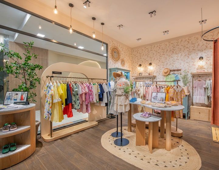 Intérieur d'une boutique Kids Brand Store avec vêtements colorés pour enfants.