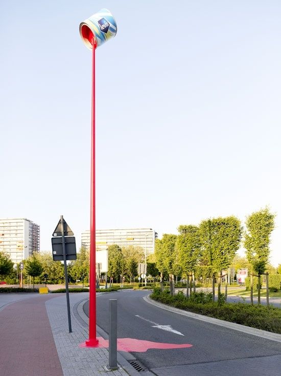 Installation urbaine en forme de boîte de conserve géante versant du liquide rouge